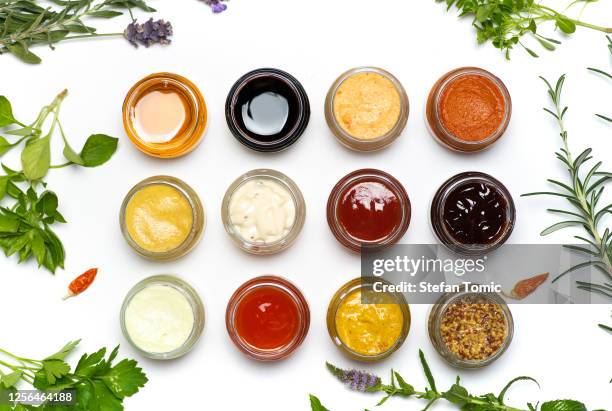 gran colección de salsas y extices especiados en pequeños frascos aislados planos yacía - condiment fotografías e imágenes de stock