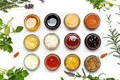 Large collection of sauces and spiced spreads in small jars isolated flat lay