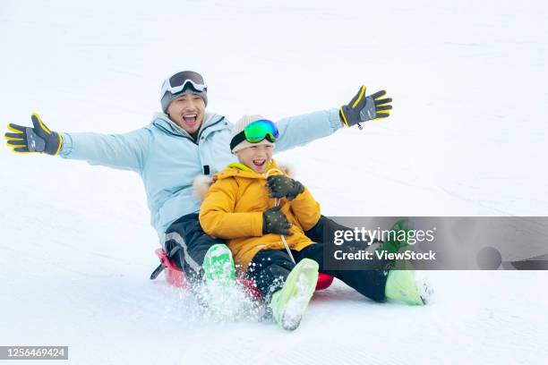 happy father and son sat snow snowboarding - chinese father and son snow stock pictures, royalty-free photos & images