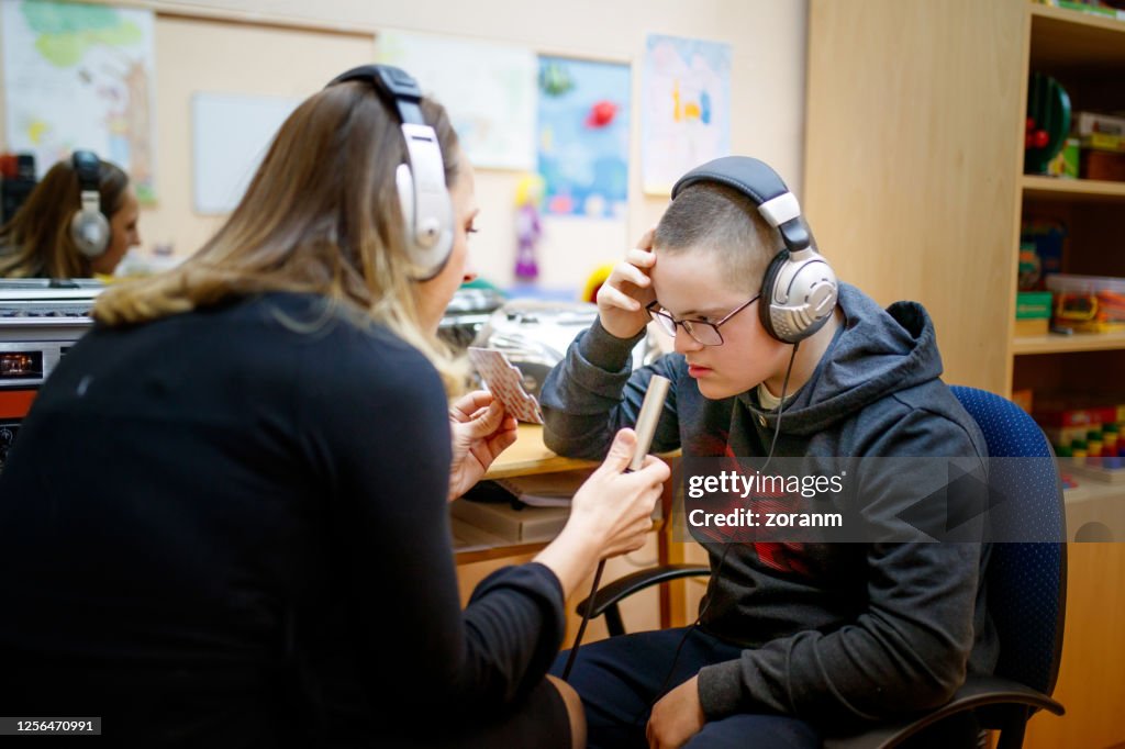 Teen boy with special needs working with speech therapist