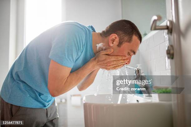 man washing his face after shaving - man shaving face stock pictures, royalty-free photos & images