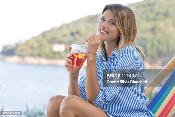 beautiful woman drinking by the sea - aperol spritz stock pictures, royalty-free photos & images