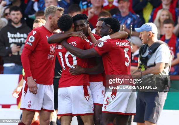 Nottingham Forest's Nigerian striker Taiwo Awoniyi is mobbed by teammates after scoring the opening goal during the English Premier League football...