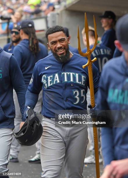 Teoscar Hernandez of the Seattle Mariners holds the home run celebration trident in the dugout after hitting a home run in the game against the...