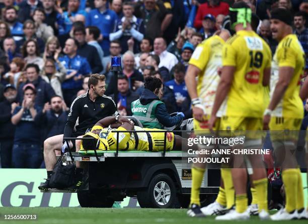 La Rochelle's French prop Georges-Henri Colombe Reazel is carried off the pitch after being injured during the European Champions Cup final rugby...