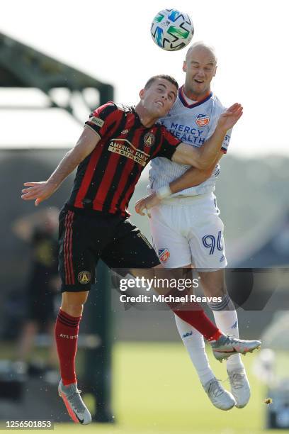 Brooks Lennon of Atlanta United and Andrew Gutman of FC Cincinnati battle for a header during a Group E match as part of the MLS Is Back Tournament...