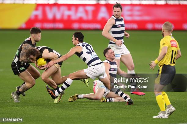 Chris Mayne of the Magpies gets tackled by Sam Simpson of the Cats during the round 7 AFL match between the Geelong Cats and the Collingwood Magpies...