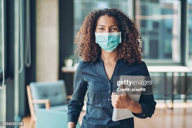 giovane donna d'affari con maschera facciale in ufficio - notebook smiling business foto e immagini stock