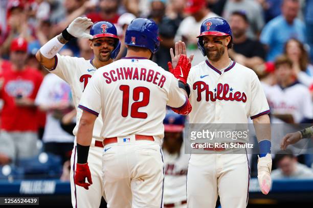 May 20: Kyle Schwarber of the Philadelphia Phillies is congratulated by Nick Castellanos and Bryce Harper after he hit a grand slam home run against...
