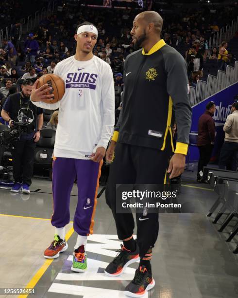 Andre Iguodala of the Golden State Warriors and Damion Lee of the Phoenix Suns talk before the game against the Golden State Warriors on January 10,...