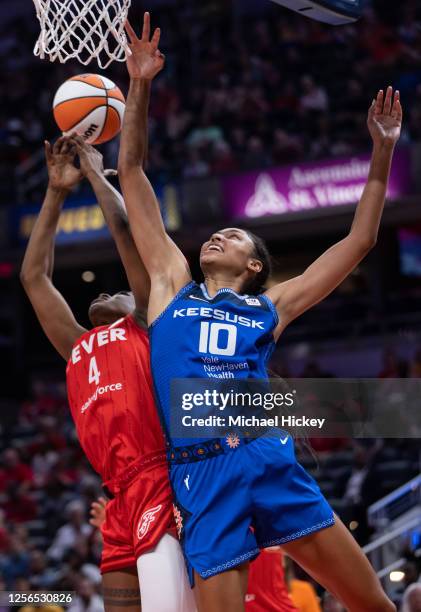 Queen Egbo of the Indiana Fever and Olivia Nelson-Ododa of the Connecticut Sun reach for the ball at Gainbridge Fieldhouse on May 19, 2023 in...