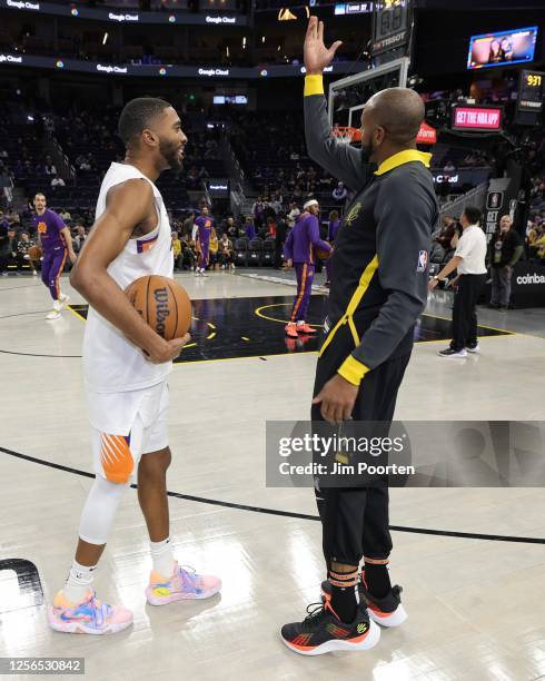 Mikal Bridges of the Phoenix Suns and Andre Iguodala of the Golden State Warriors talk before the game against the Phoenix Suns on January 10, 2023...