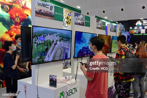 Visitors play video games at the Xbox stand during 2020 China International Cartoon and Game Expo at Shanghai World Expo Exhibition and Convention...