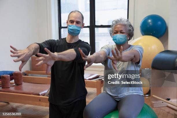 在康復中心做運動的人戴著面具。 - yoga ball work 個照片及圖片檔