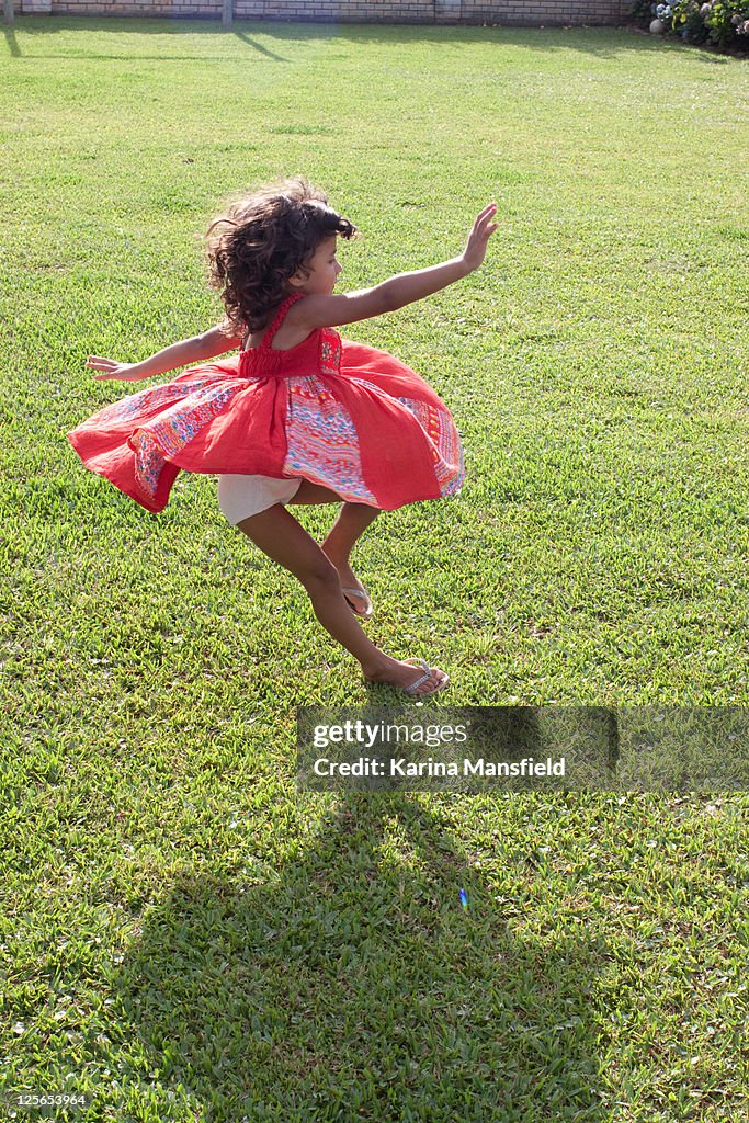 Girl with red dress playing on grass