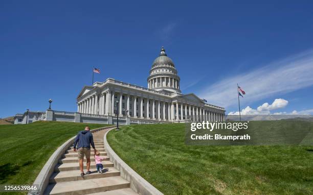 padre e figlia che camminano verso il campidoglio dello utah a salt lake city durante il giorno - salt lake city   utah foto e immagini stock