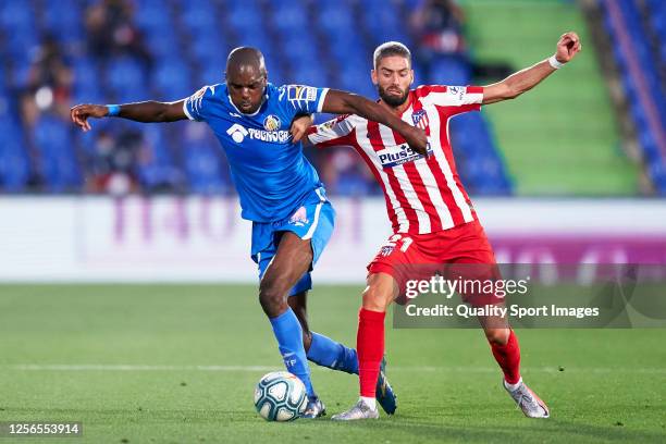 Allan Romeo Nyom of Getafe CF competes for the ball with Yannick Carrasco of Club Atletico de Madrid during the La Liga match between Getafe CF and...