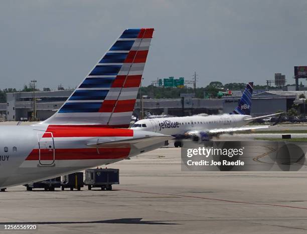 JetBlue plane taxis to its gate past an American Airlines plane at the Fort Lauderdale-Hollywood International Airport on July 16, 2020 in Fort...