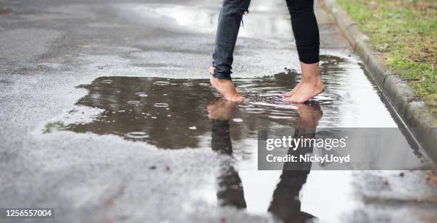 couples dans une flaque d’eau - couples kissing shower photos et images de collection