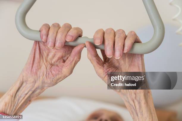 oude vrouwelijke handen die een handvat in het ziekenhuis houden - hospitium stockfoto's en -beelden