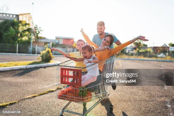 family having fun after grocery shopping - man pushing cart fun play stock pictures, royalty-free photos & images