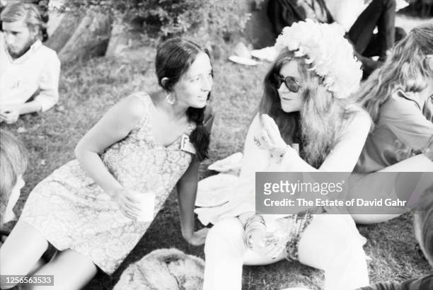 American folk and blues singer Maria Muldaur and rock and blues singer Janis Joplin share time together backstage in July, 1968 at the Newport Folk...