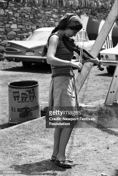 American folk and blues singer Maria Muldaur poses backstage practicing her fiddle before a performance with old-timey group Jim Kweskin Jug Band in...