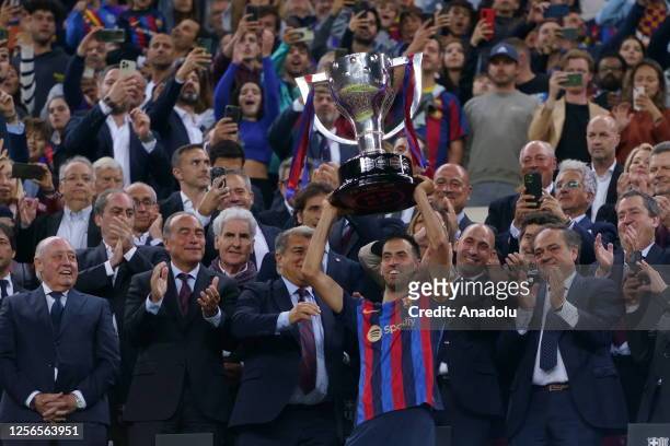 Barcelona's Spanish midfielder Sergio Busquets holds a Spanish trophy during the celebrations at the end of the Spanish league football match between...