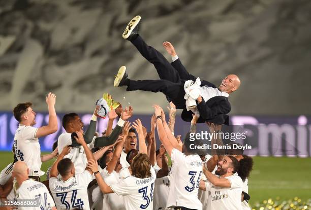 Real Madrid head coach Zinedine Zidane is thrown up in the air by his players after Madrid secure the La Liga title during the Liga match between...