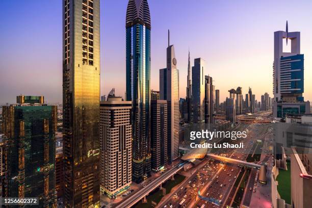 high angle views of urban skyline and skyscrapers at sunset in dubai uae. - west asia stock pictures, royalty-free photos & images