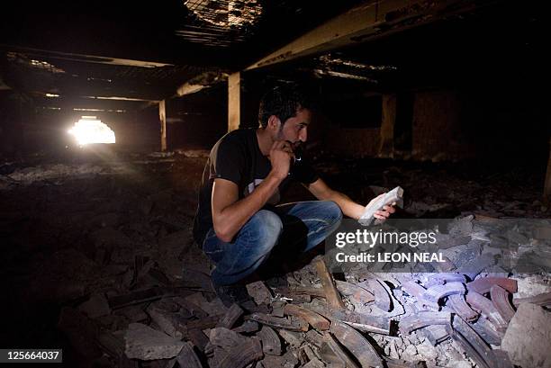 Libyan man inspects a large pile of ammunition magazines in a former government weapons store in central Tripoli on September 19, 2011. During the...