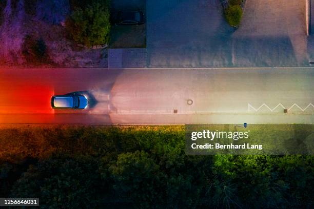 car on a street at night, high angle view - dark street stock-fotos und bilder