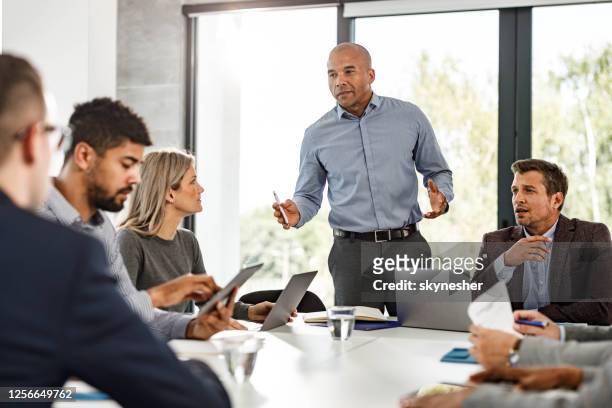 el ceo afroamericano habla con su equipo en una reunión en la oficina. - business meeting fotografías e imágenes de stock