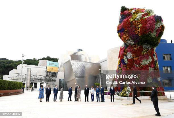 King Felipe of Spain and Queen Letizia of Spain with dignitaries and a floral sculpture called Puppy by Jeff Koons during a visit to the Guggenheim...
