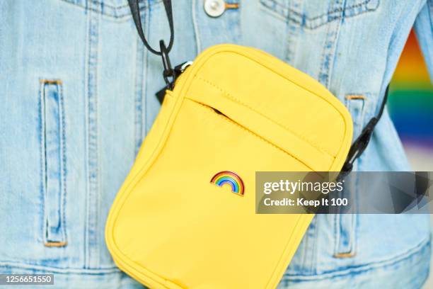 close-up of a rainbow badge on a yellow bag - yellow coat stock-fotos und bilder