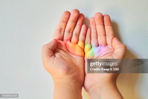 close-up of child's hand - rainbow kids stock-fotos und bilder