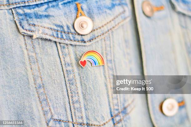 close-up of a heart rainbow badge on denim jacket pocket - door close button stockfoto's en -beelden