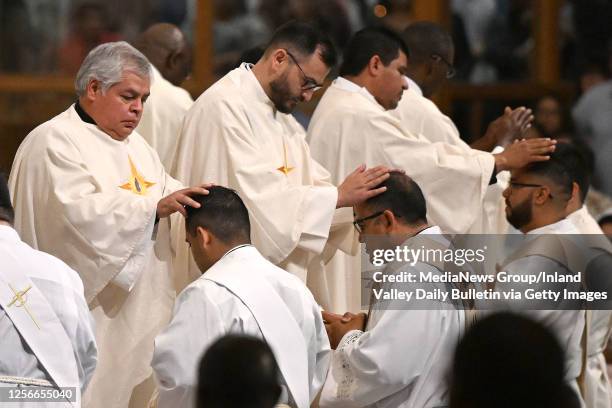 Chino Hills, CA Priests perform the Laying On of Hands to the 7 transitional deacons during their Ordination to the Priesthood mass at St. Paul the...