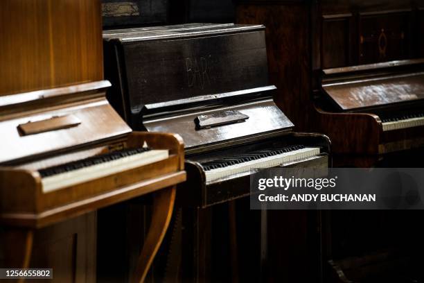 Pianos are pictured at the Painodrome, a charity centre aiming a the refurbishing and repairing pianos, located in a former department store near the...