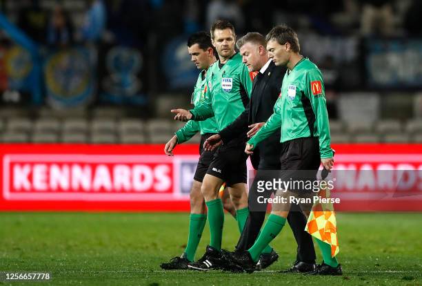 Ufuk Talay, manager of the Phoenix, speaks with the referees on the pitch at half time on during the round 21 A-League match between Sydney FC and...