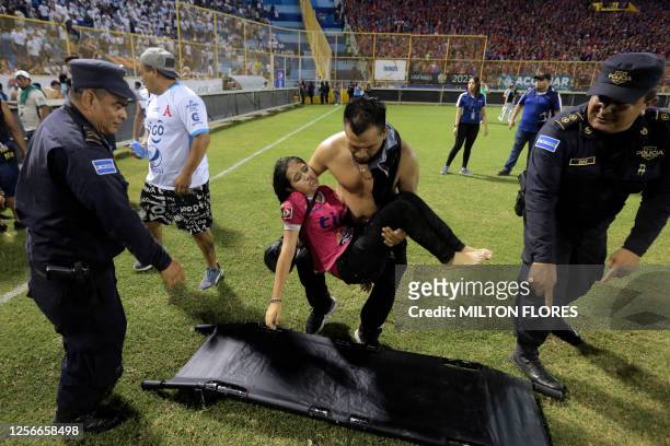 Supporters are helped by others following a stampede during a football match between Alianza and FAS at Cuscatlan stadium in San Salvador, on May 20,...