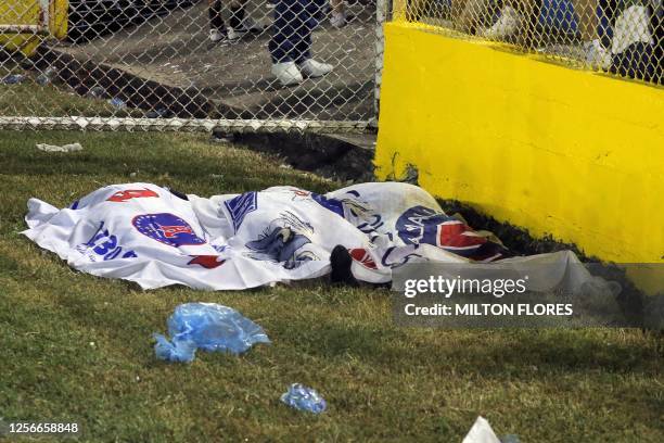 Graphic content / Victims' bodies are seen covered with Alianza's flags following a stampede during a football match between Alianza and FAS at...