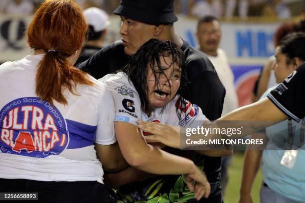 Woman is held by other as she cries following a stampede during a football match between Alianza and FAS at Cuscatlan stadium in San Salvador, on May...