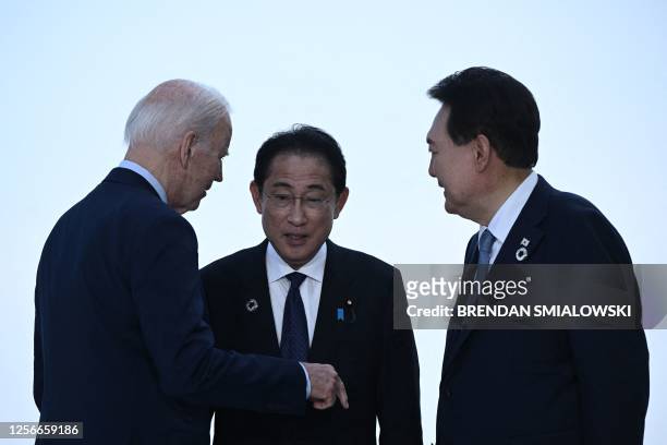 President Joe Biden, Japan's Prime Minister Fumio Kishida, and South Korea's President Yoon Suk Yeol greet each other ahead of a trilateral meeting...