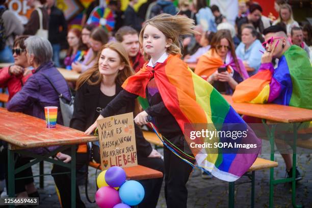 Kid with a pride flags takes part in Christopher Street Day parade. Christopher Street Day is an annual LGBTQ+ celebration and demonstration for the...