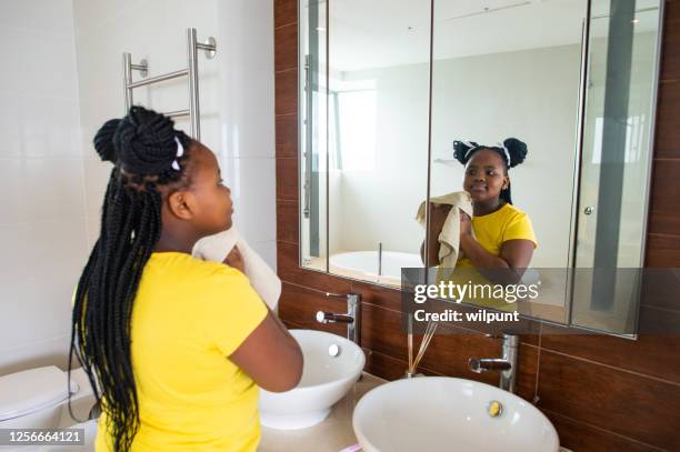 girl washing and dryingh her face - girl in mirror stock pictures, royalty-free photos & images