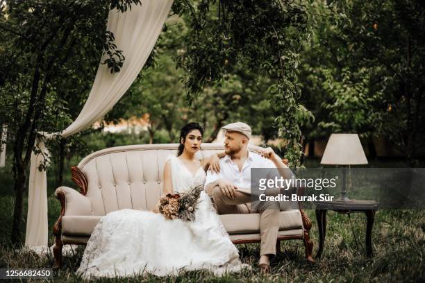 wedding photo, bride and groom sitting on the sofa and posing - embellished suit stock pictures, royalty-free photos & images
