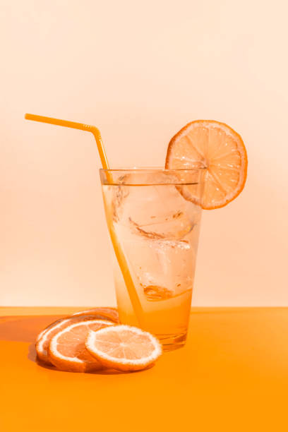 ice cold orange juice glass on orange colored table - orange cocktail stock pictures, royalty-free photos & images
