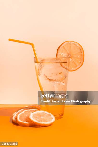 ice cold orange juice glass on orange colored table - fructose stock pictures, royalty-free photos & images