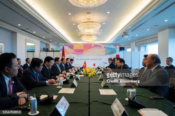 Pham Minh Chinh, Vietnam's prime minister, forth from left, speaks to Fumio Kishida, Japan's prime minister, fourth from right, during a bilateral...
